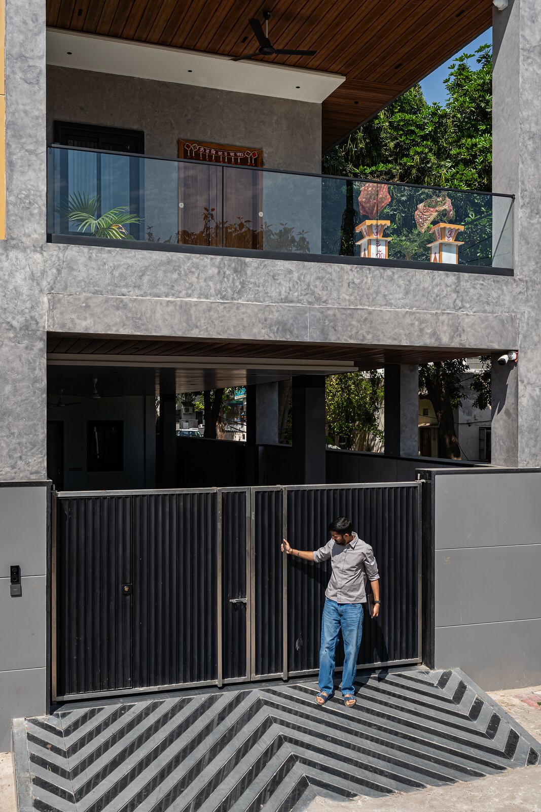 The entrance. A striped threshold under the cantilever.