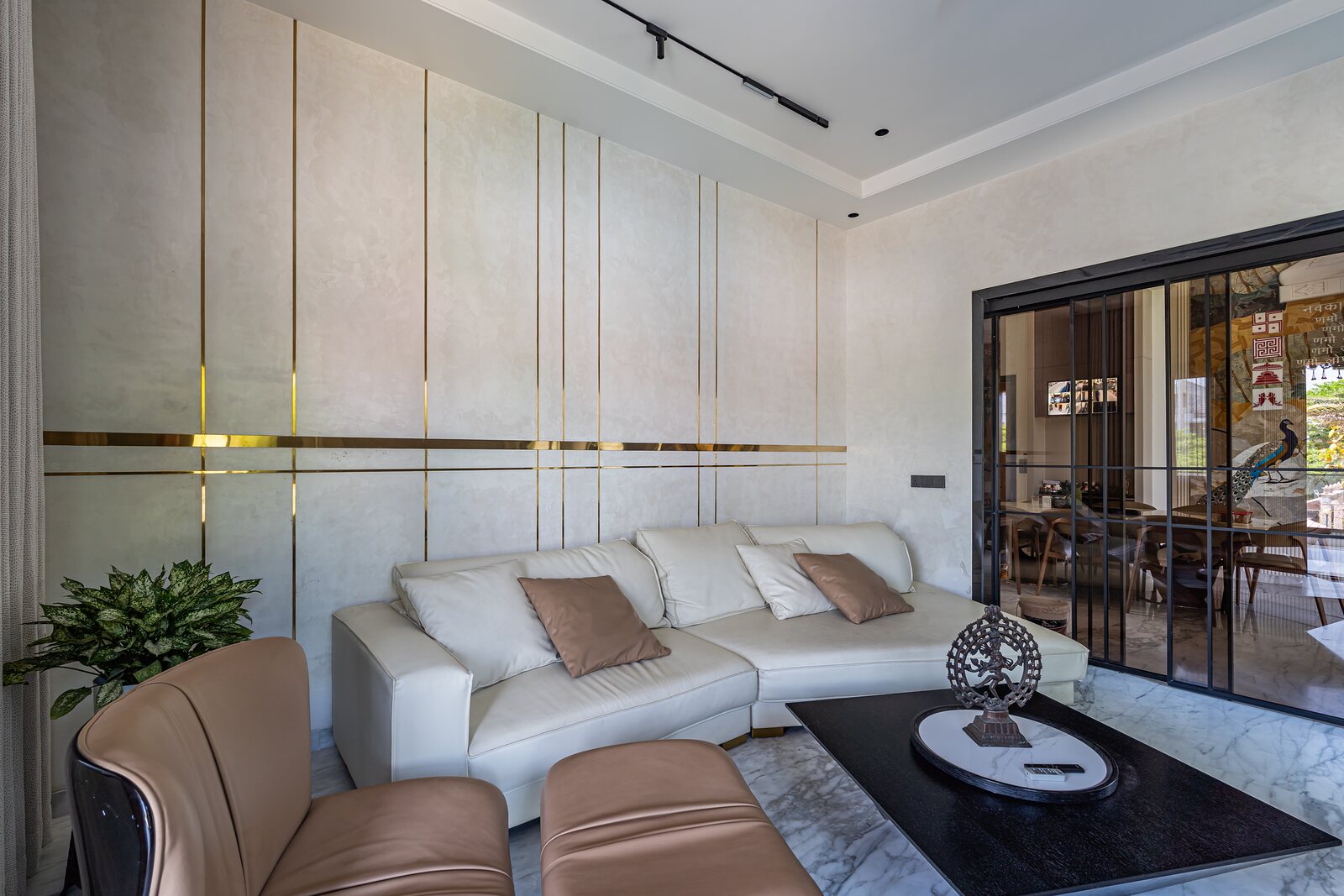 A sitting room in white leather around the media wall.