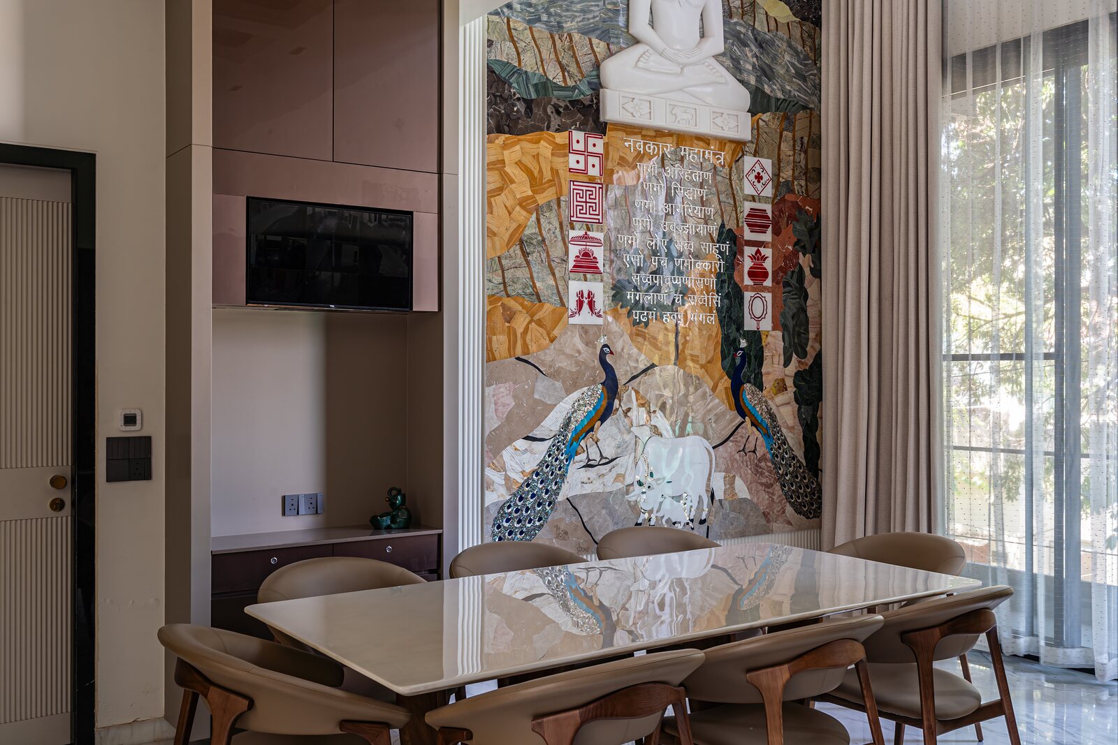The dining room, a peacock mural behind the marble table.