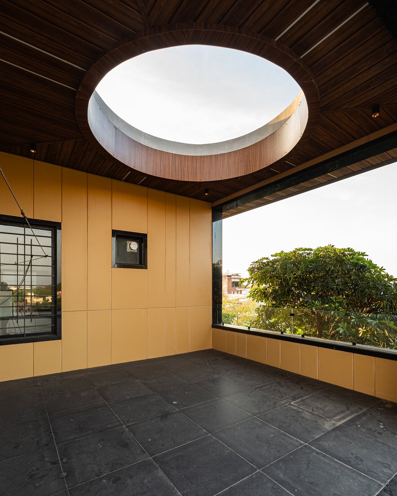 A round skylight drops light into a timber-lined room.