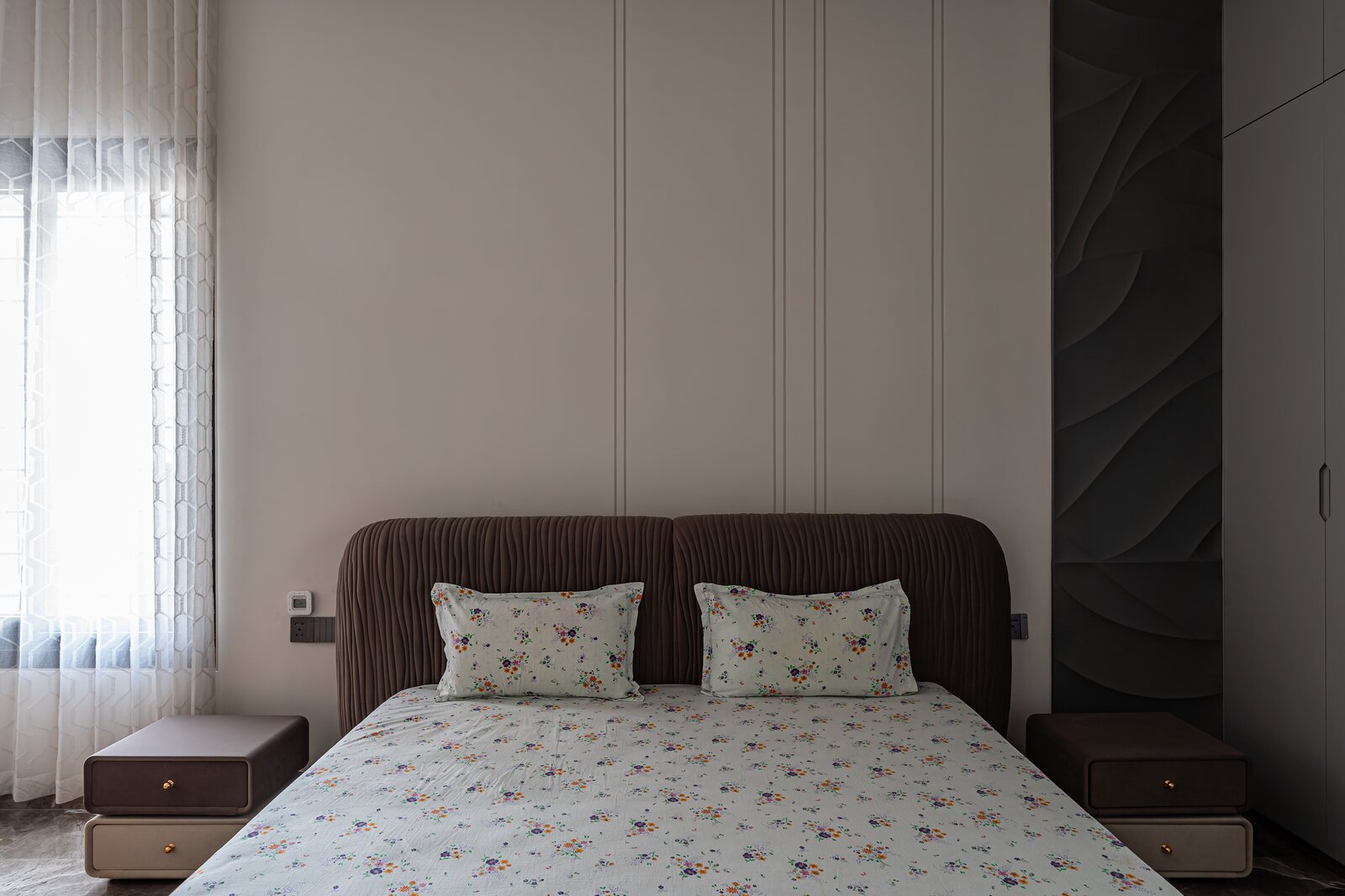 A bedroom with a brown upholstered headboard.