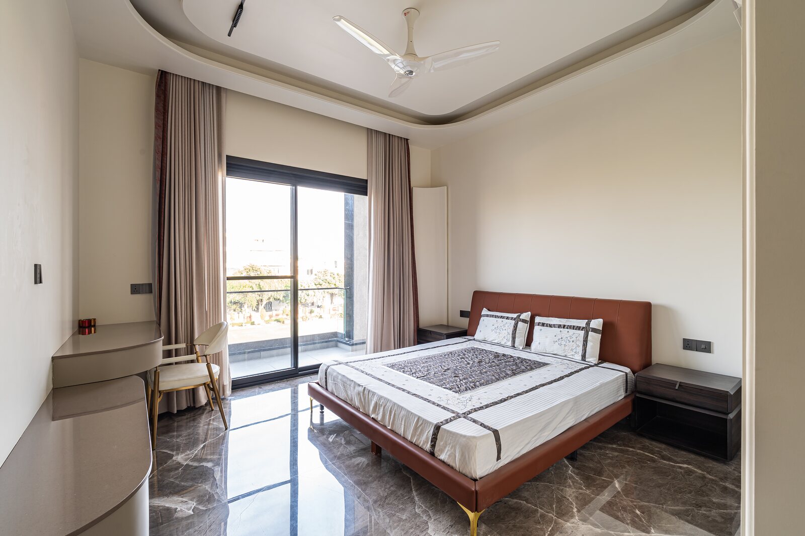 A bedroom in marble, the bed set by the window.