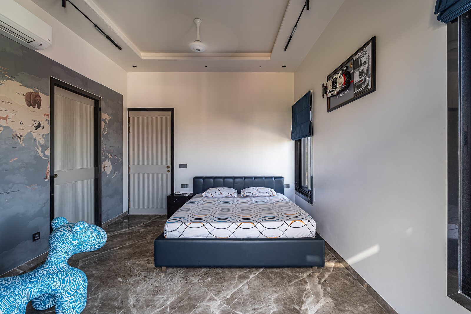 A bedroom in blue, a sculpture at its foot.