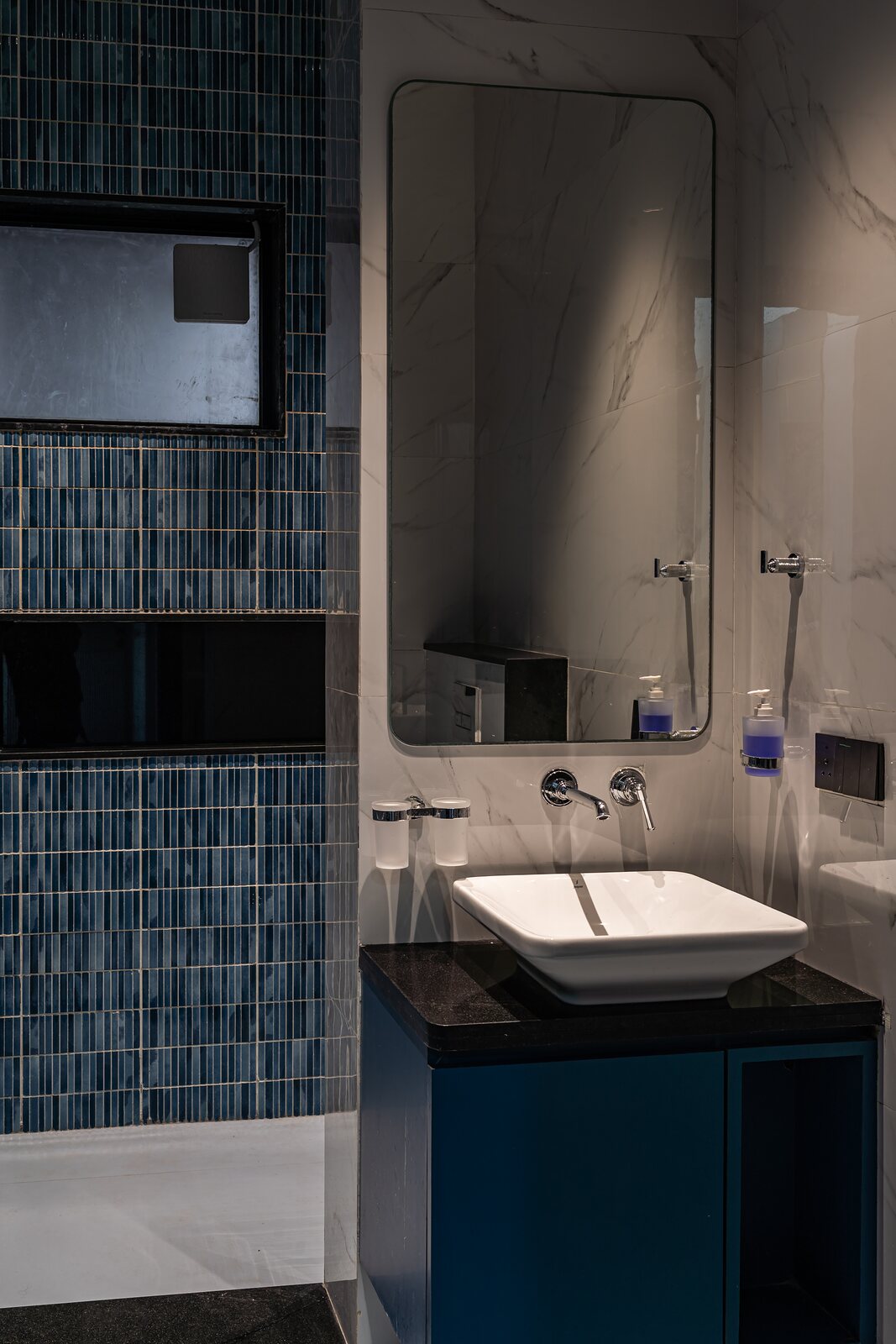 A teal-tiled bath and vanity.