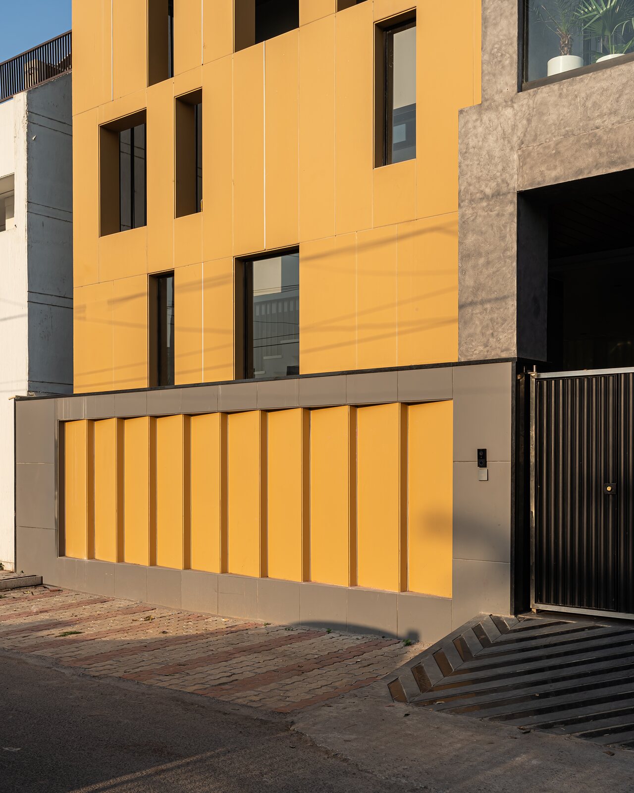 The ochre street front behind its gate.