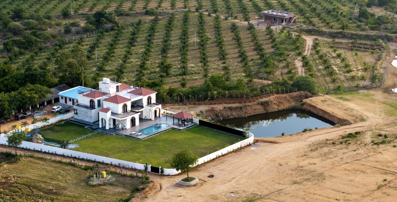 Casa del Lago from above, the house on its plot with orchards falling to the reservoir.