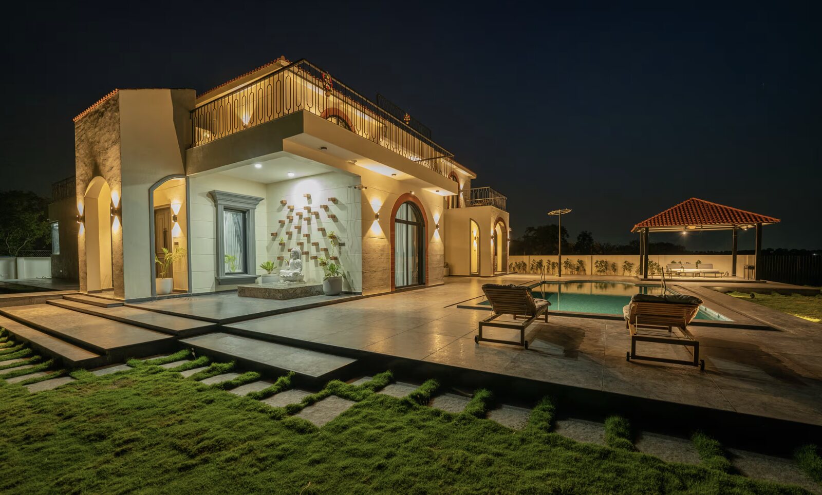 The garden front, loungers on the planted terrace.