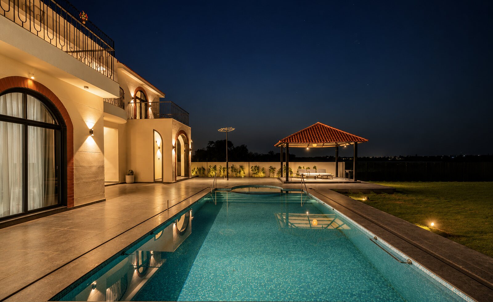 The pool at night, the pavilion mirrored in the water.