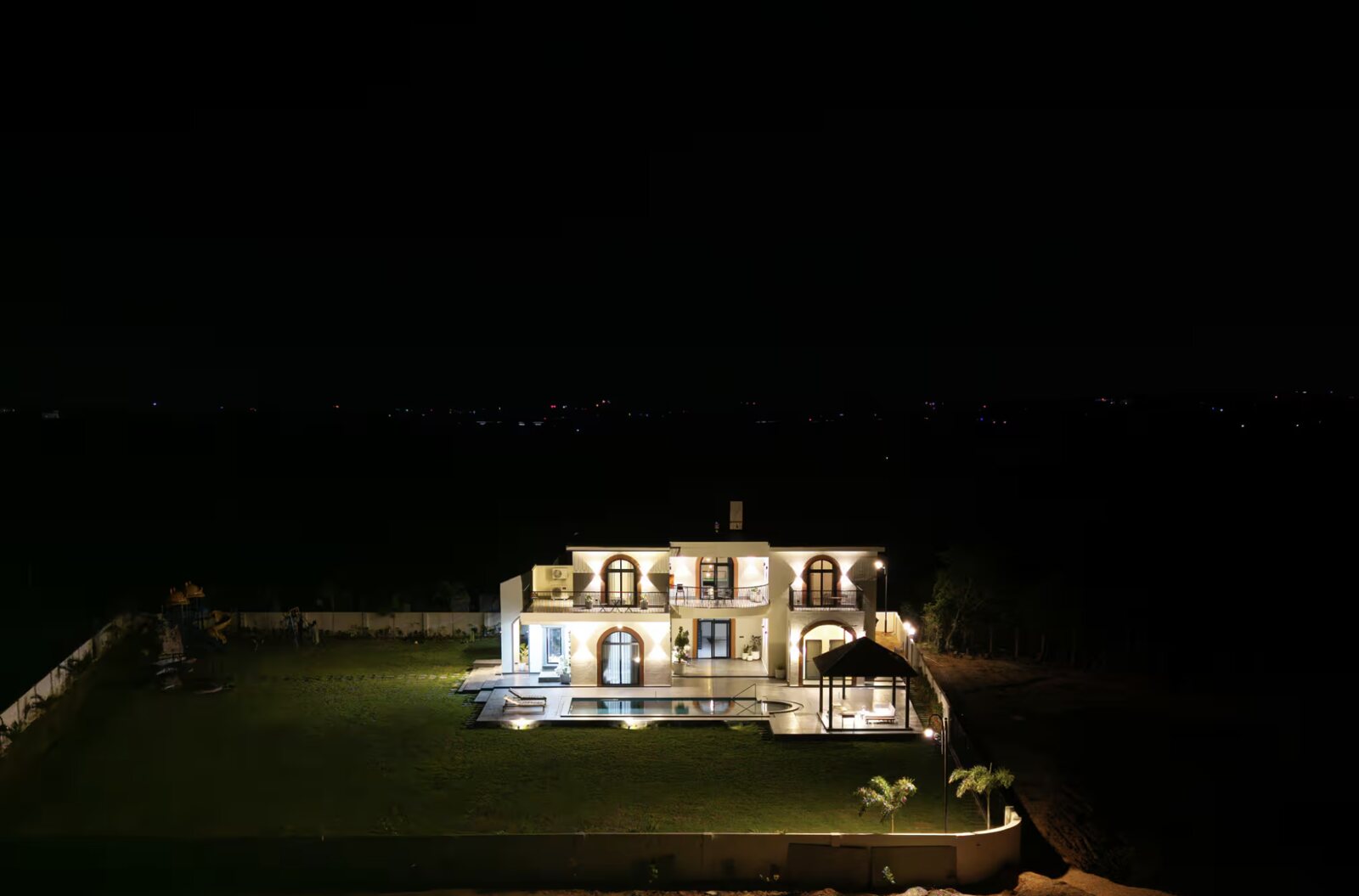 The villa alone by the water at night.