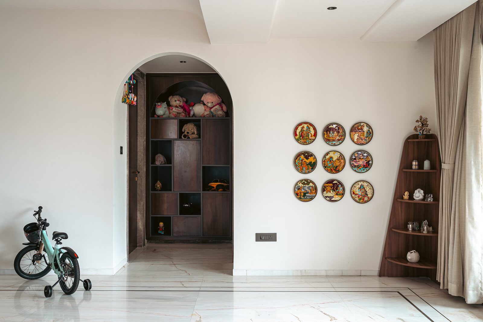 A niche of shelves beside an arched reading corner.