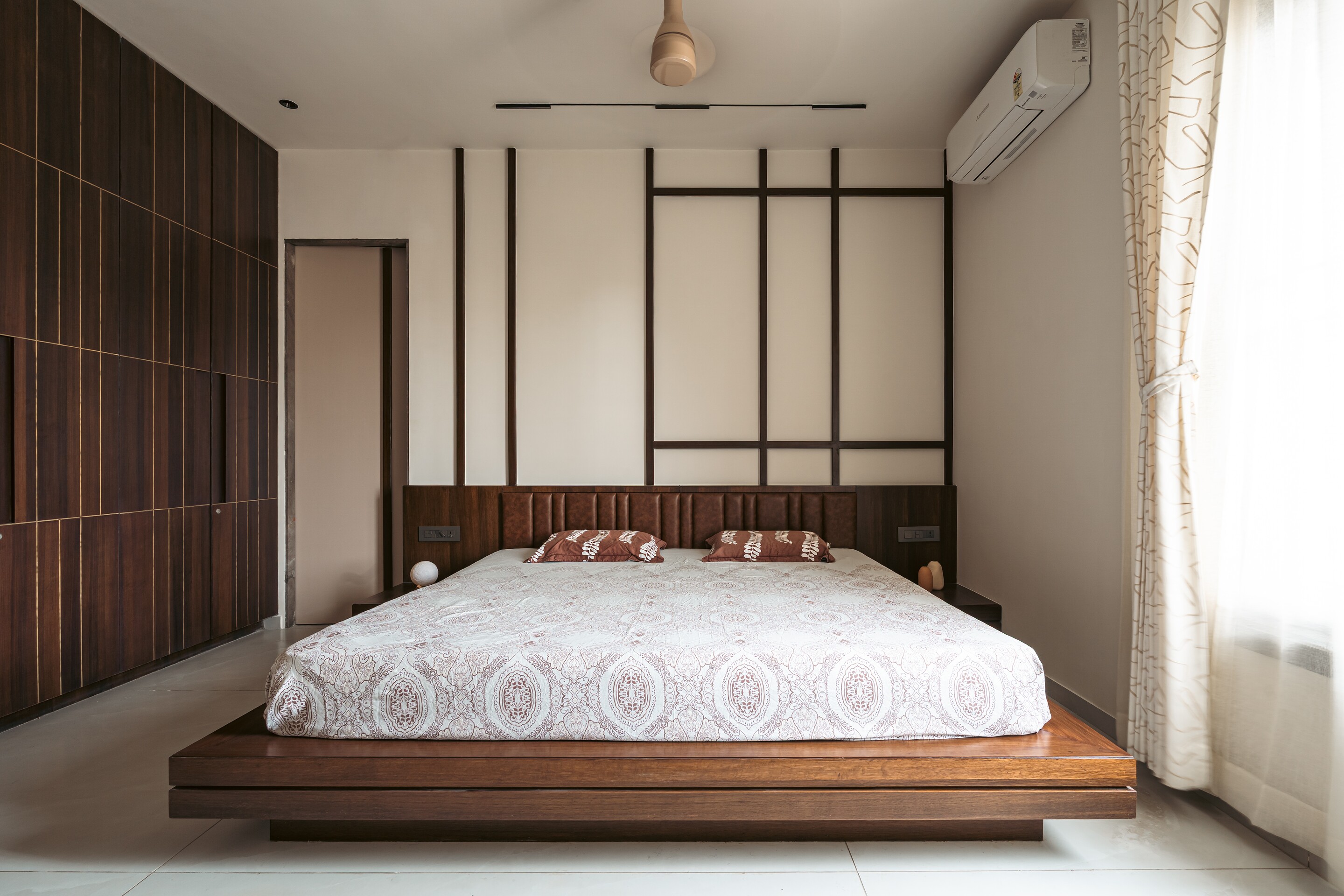 The master bedroom, a wall of timber slats behind the bed.