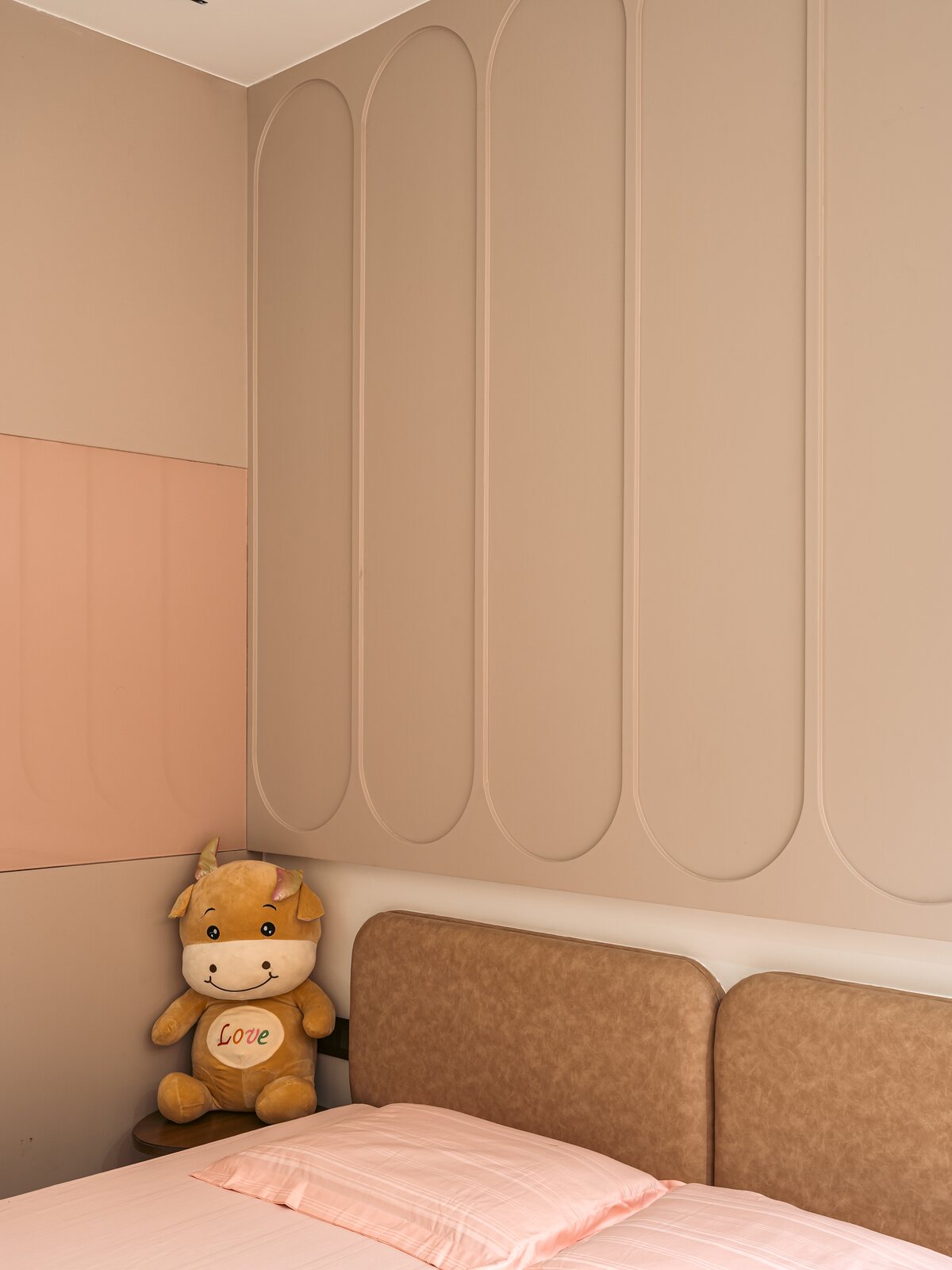 An arched niche and a low bed in blush.