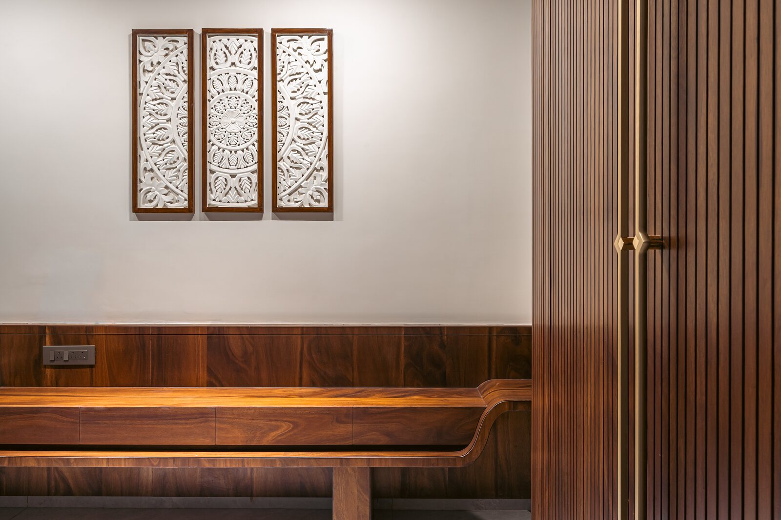 Carved panels above a timber bench.