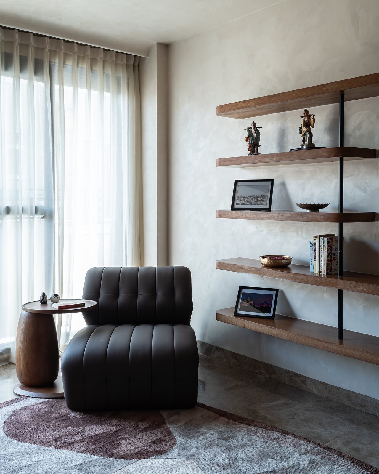 A tufted leather chair below the shelves.