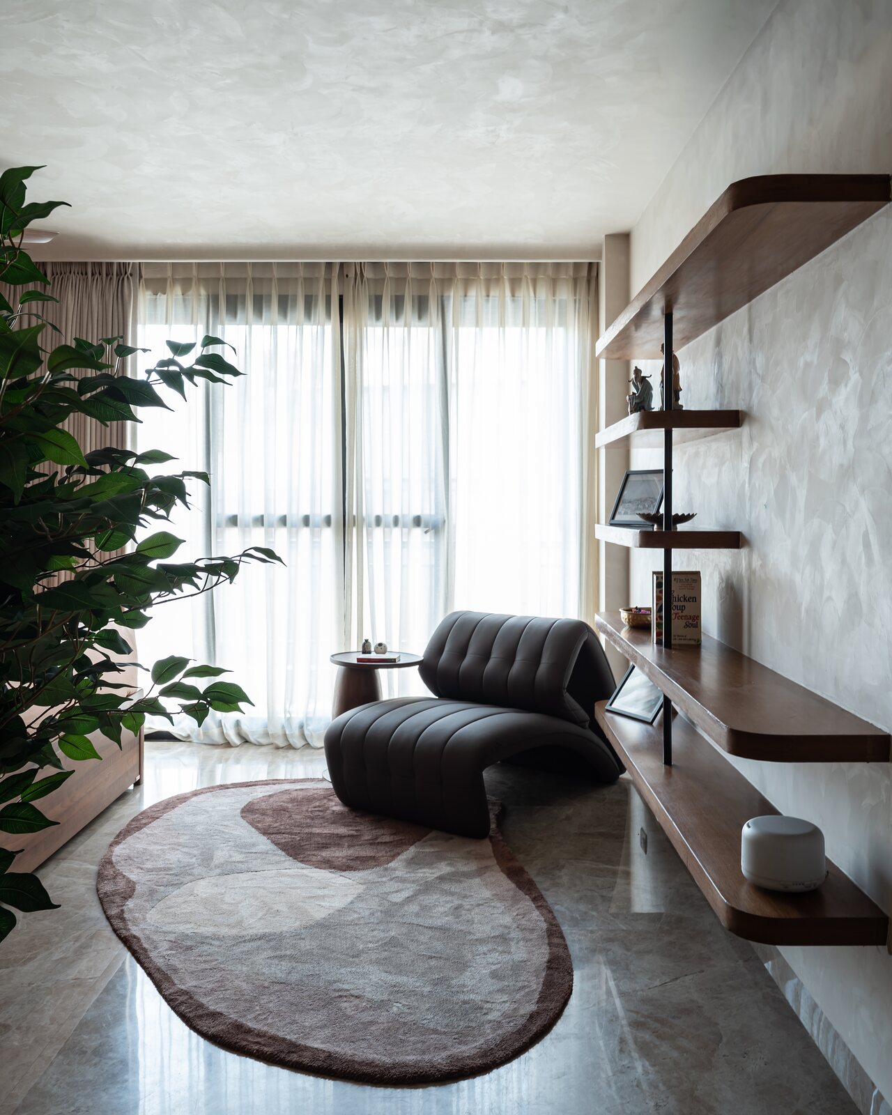 A leather chaise on an oval rug.