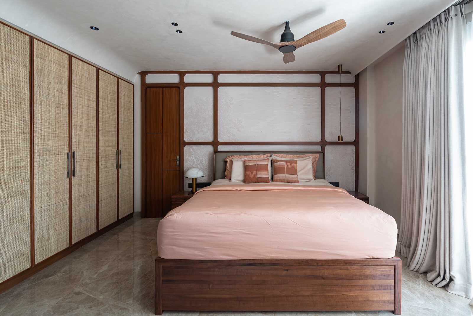 A bedroom, a timber grid over the blush bed.