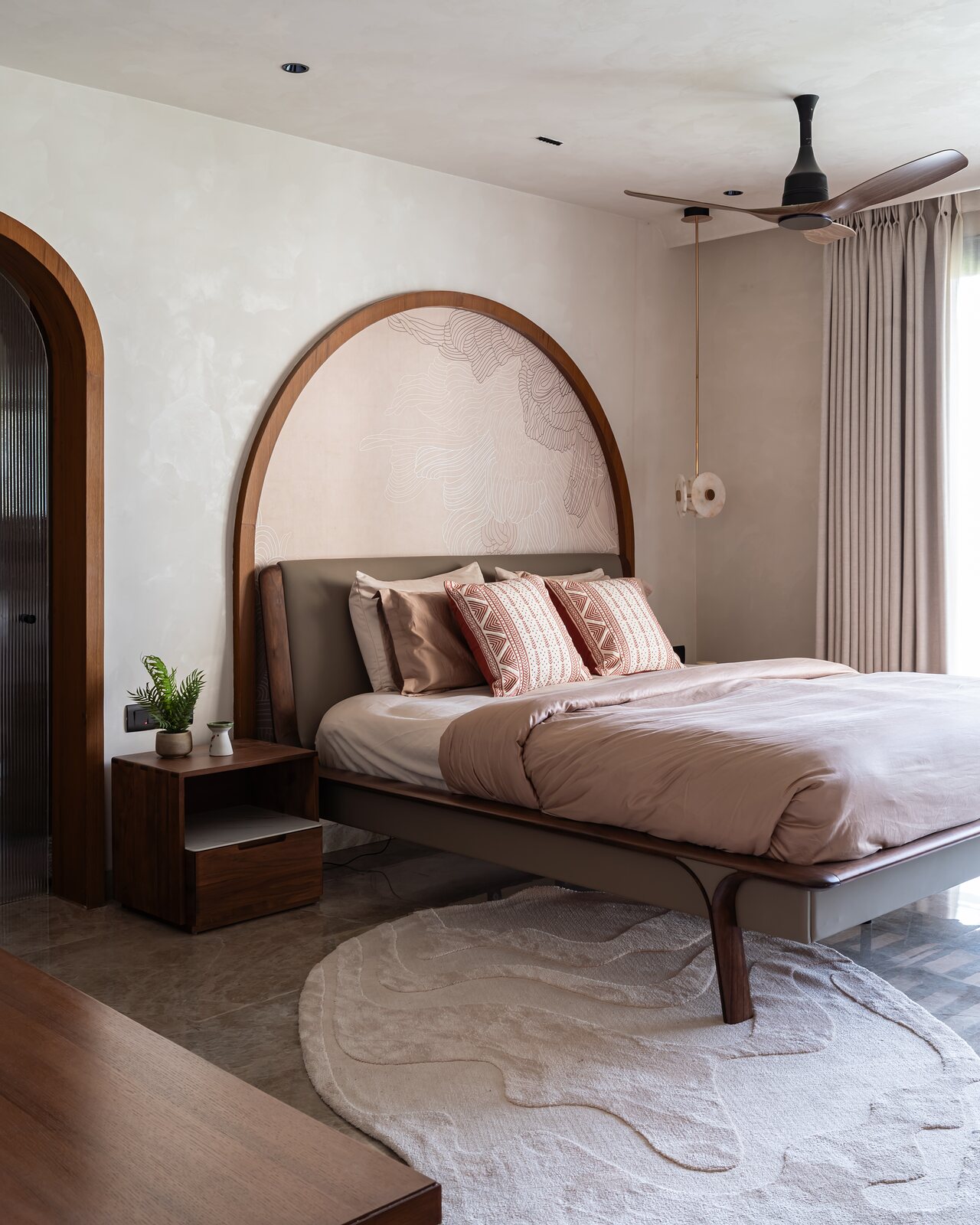 An arched headboard framed in walnut, a wave mural within.