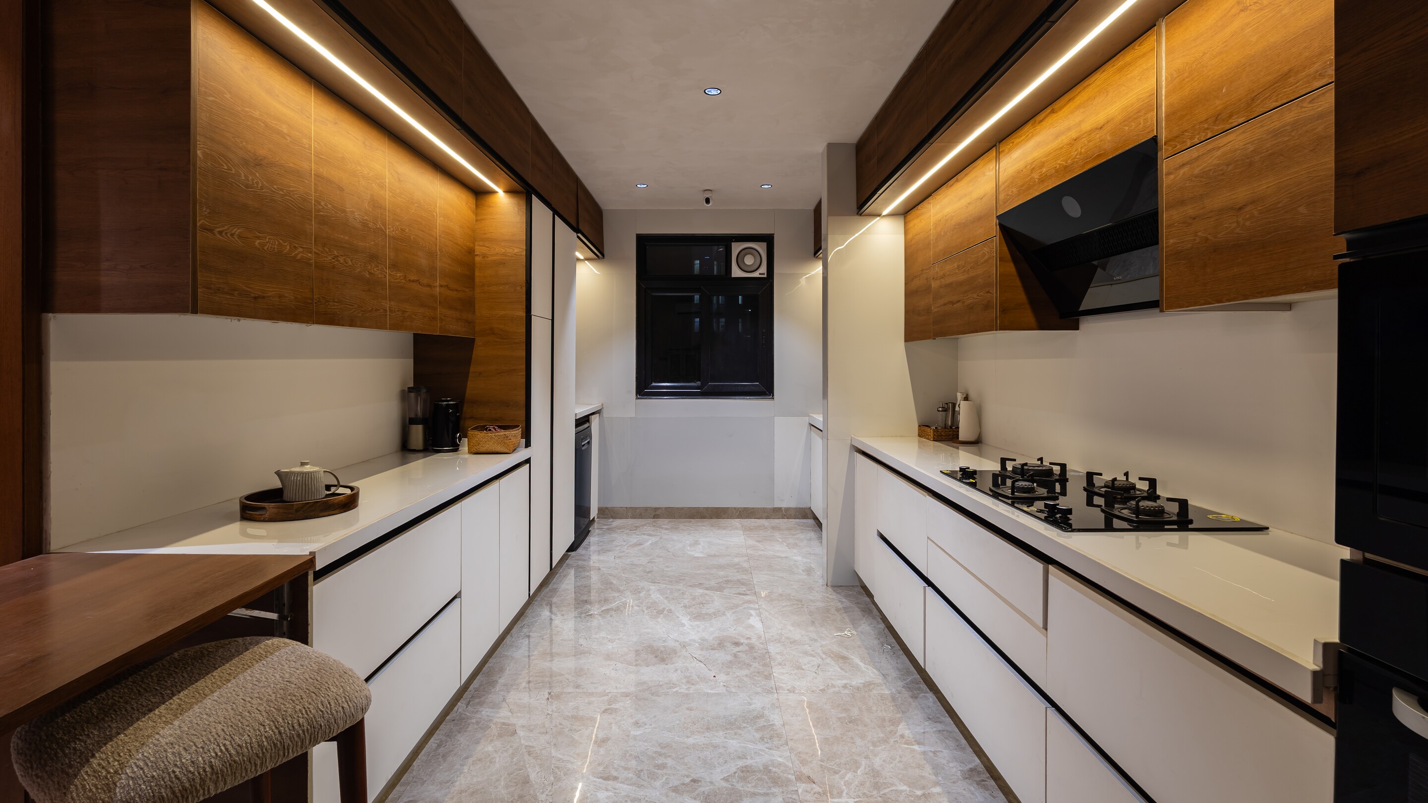 The kitchen runs long in walnut and white.
