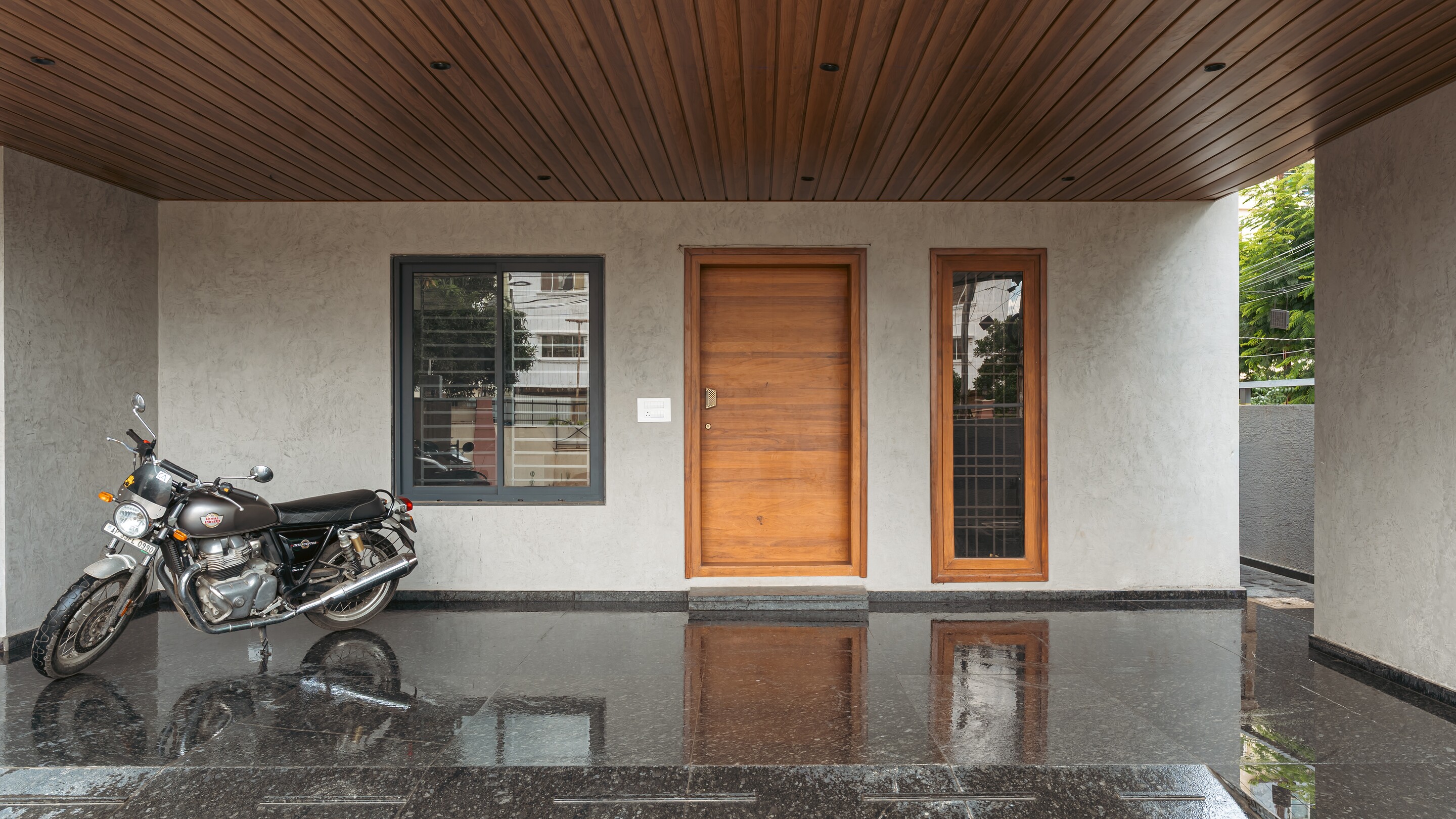 The entrance porch. A teak door on a stone floor.