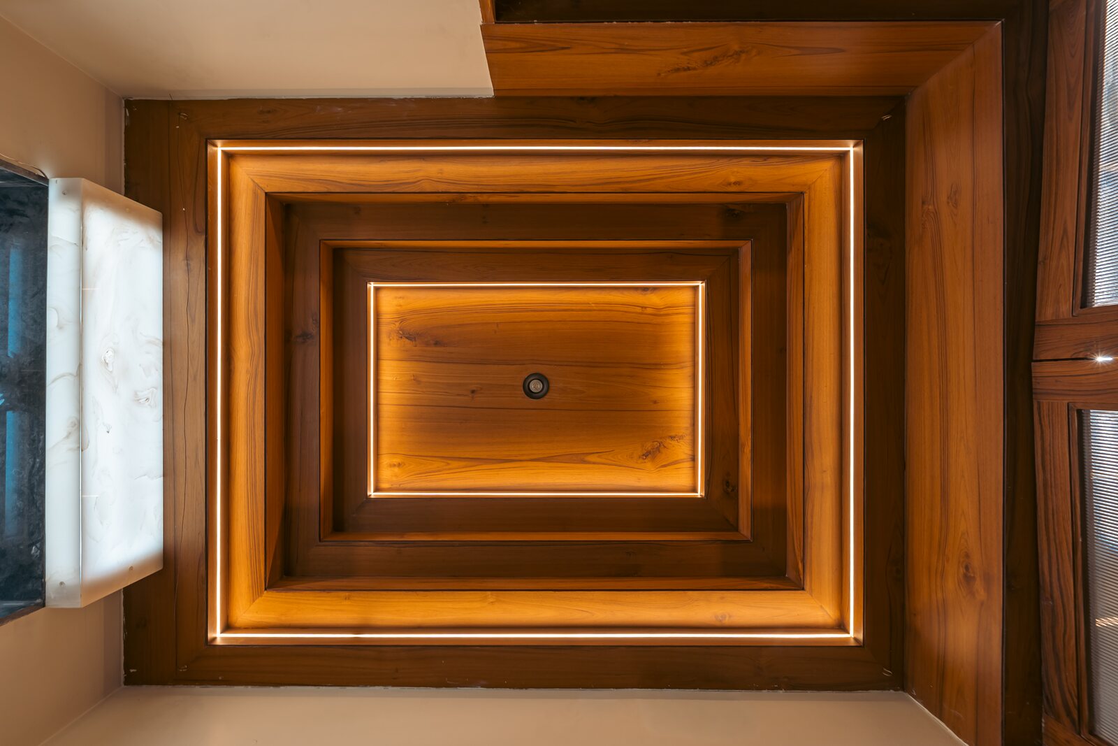 A coffered timber ceiling, lit at its center.