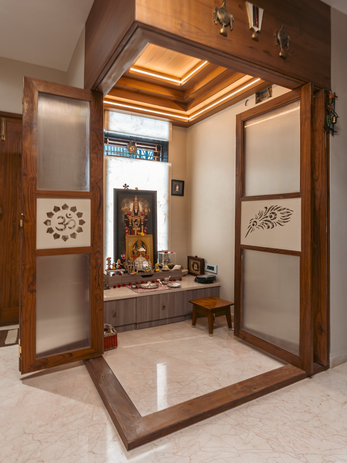 The pooja room, framed in carved teak.
