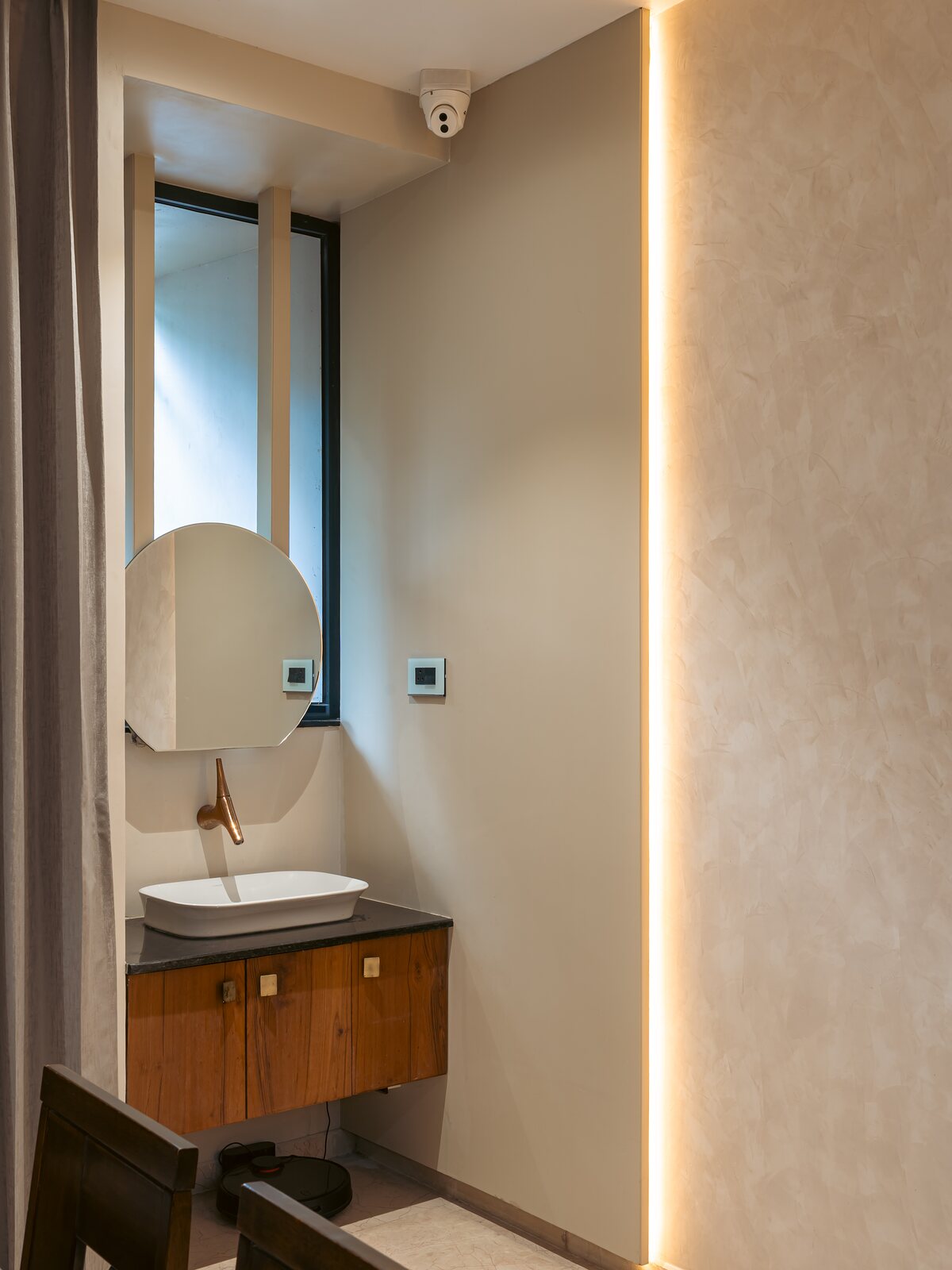 A basin set in timber under a slim mirror.