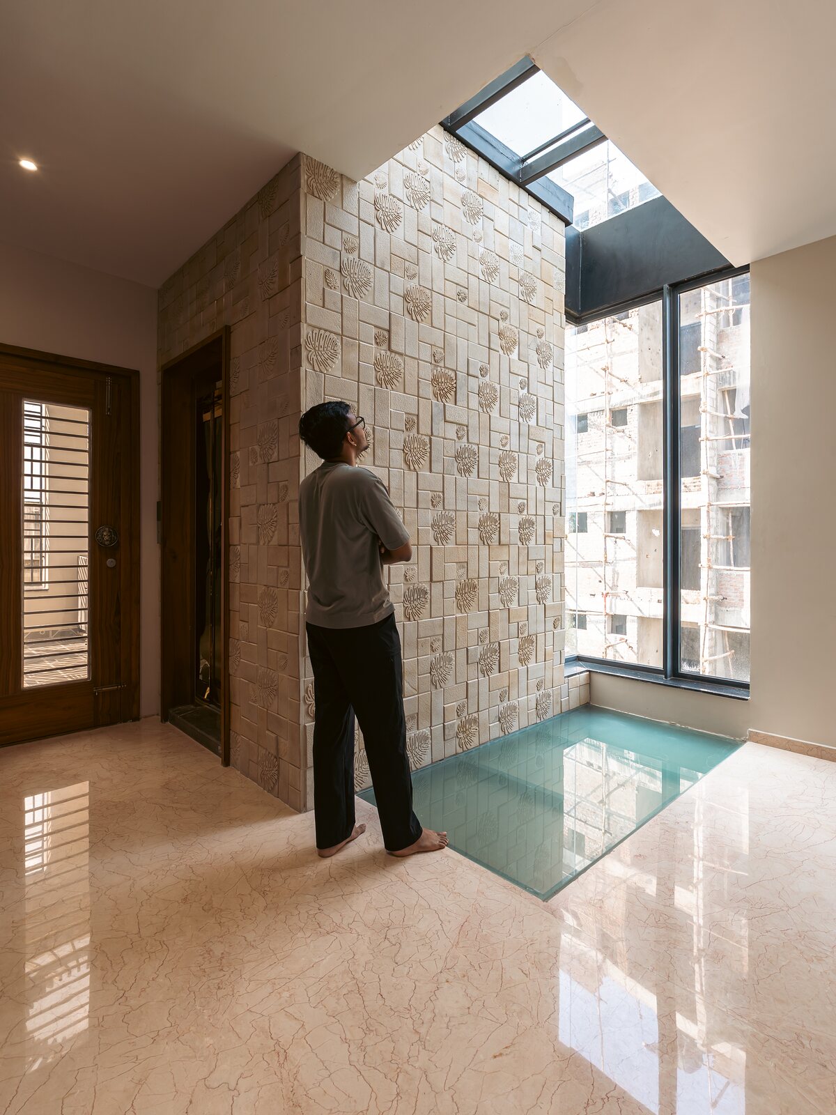 A glass floor panel drops light to the level below.