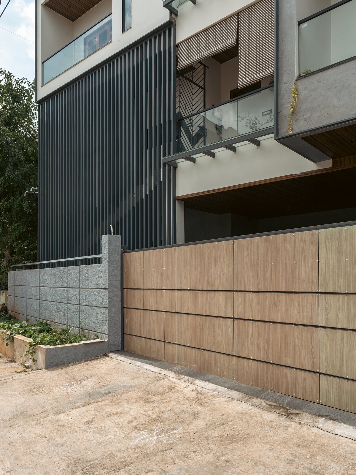 Metal cladding meets the stone boundary wall.