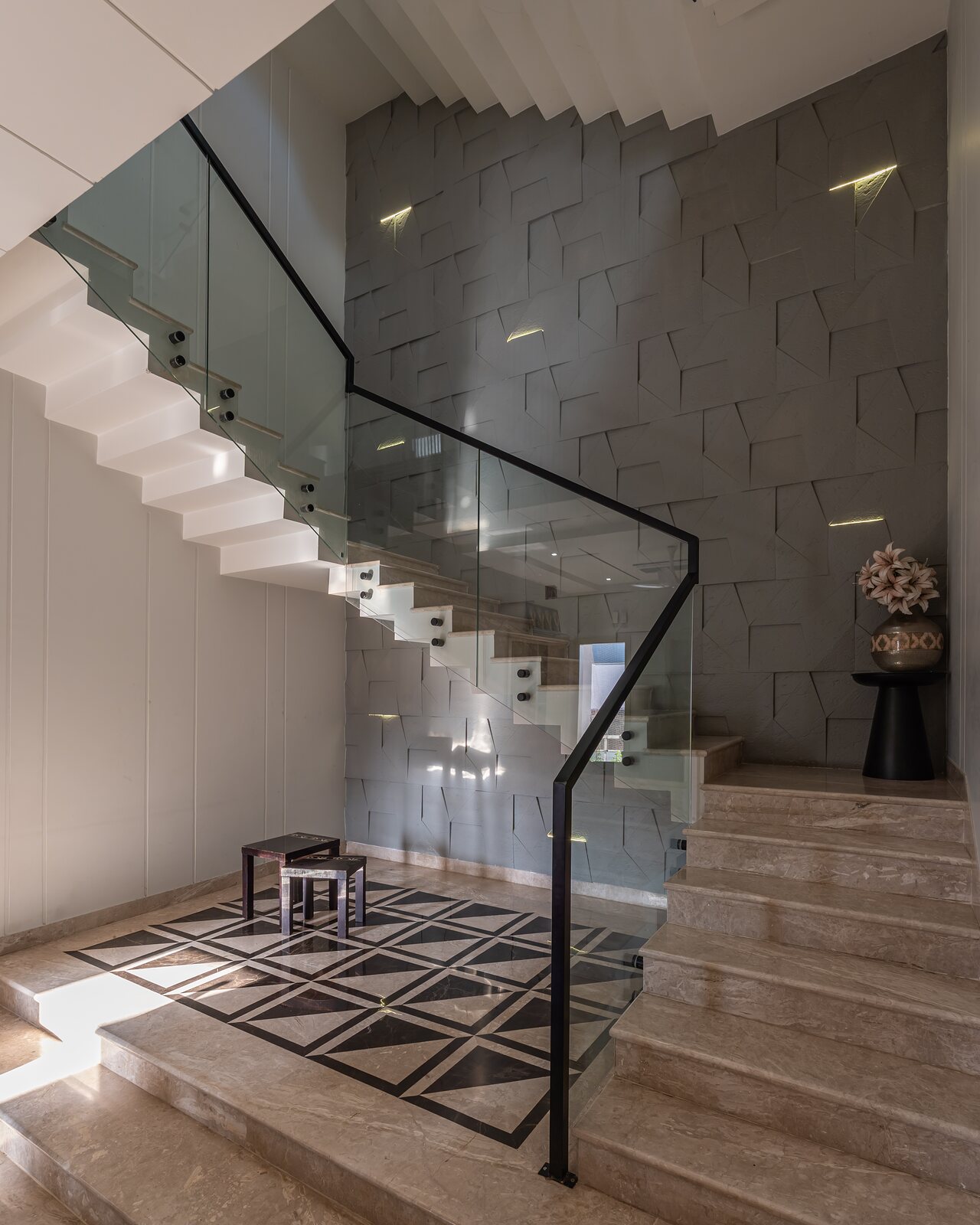 The main stair against a textured stone wall.