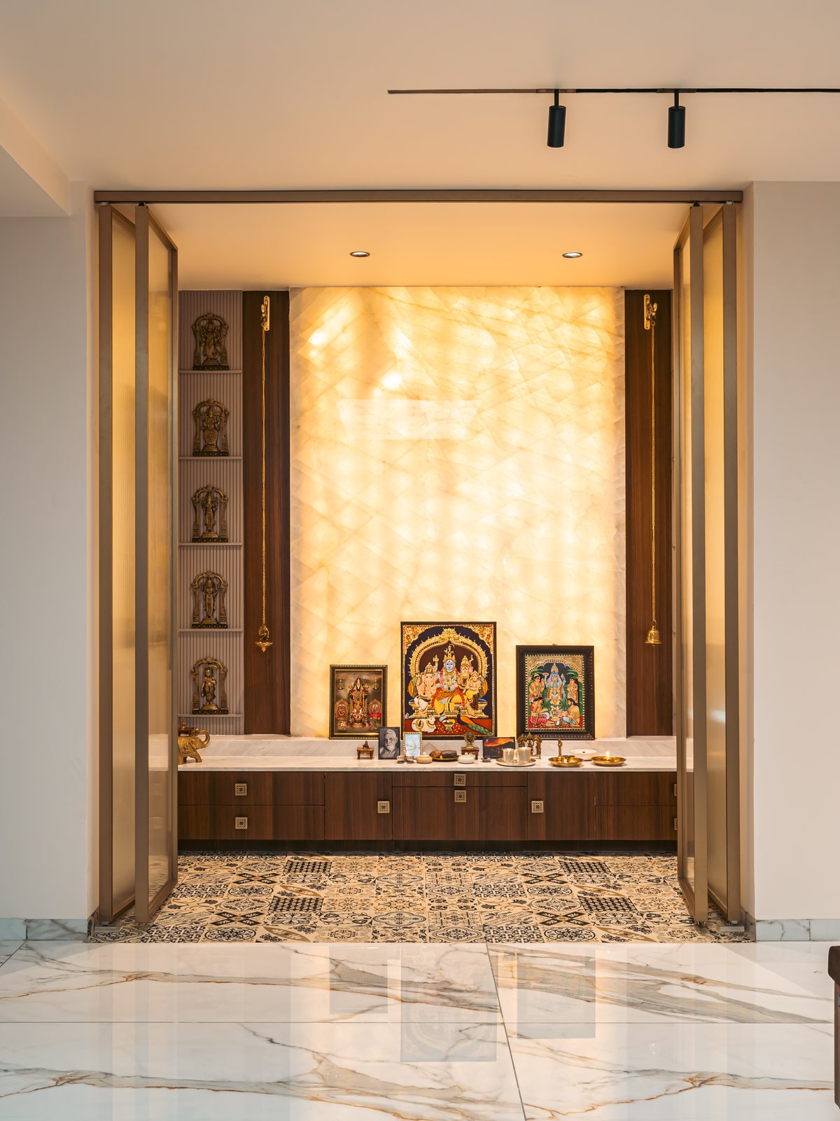 The pooja, deities lit in backlit onyx.
