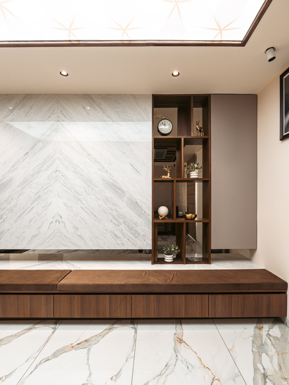 The marble wall and its walnut shelving.