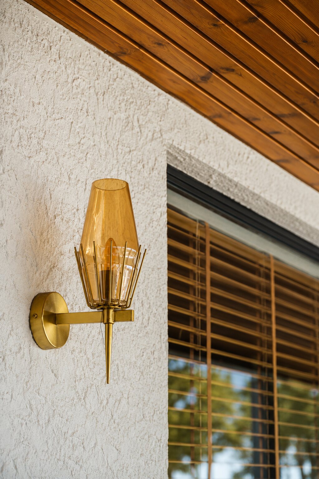 A brass sconce on lime plaster.