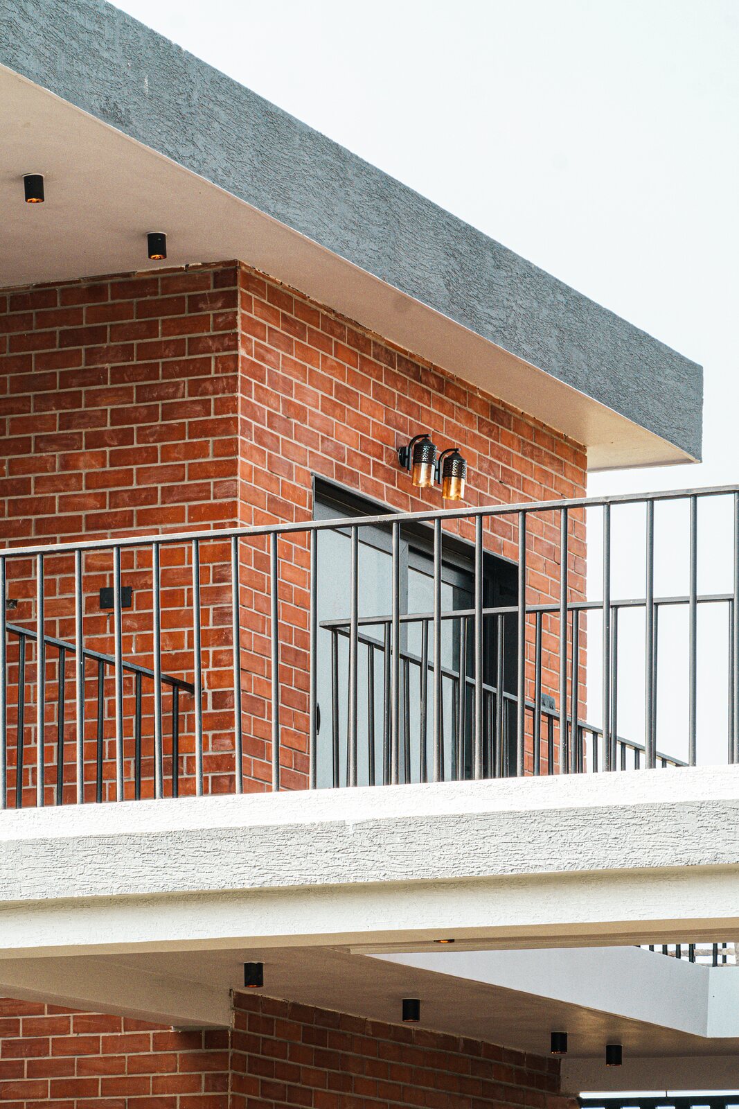 Red brick under a cantilevered balcony.
