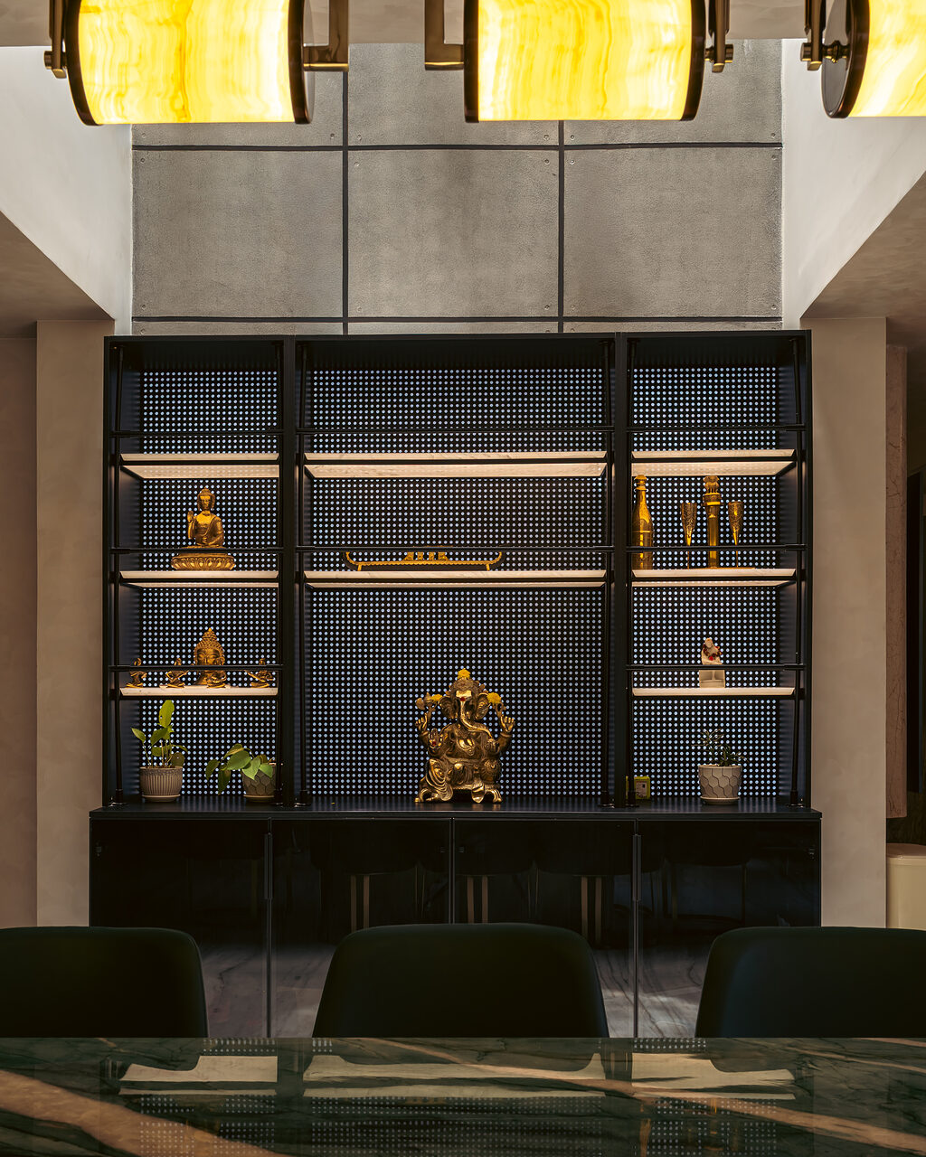 A double-height wall of black lattice, lit object by object.