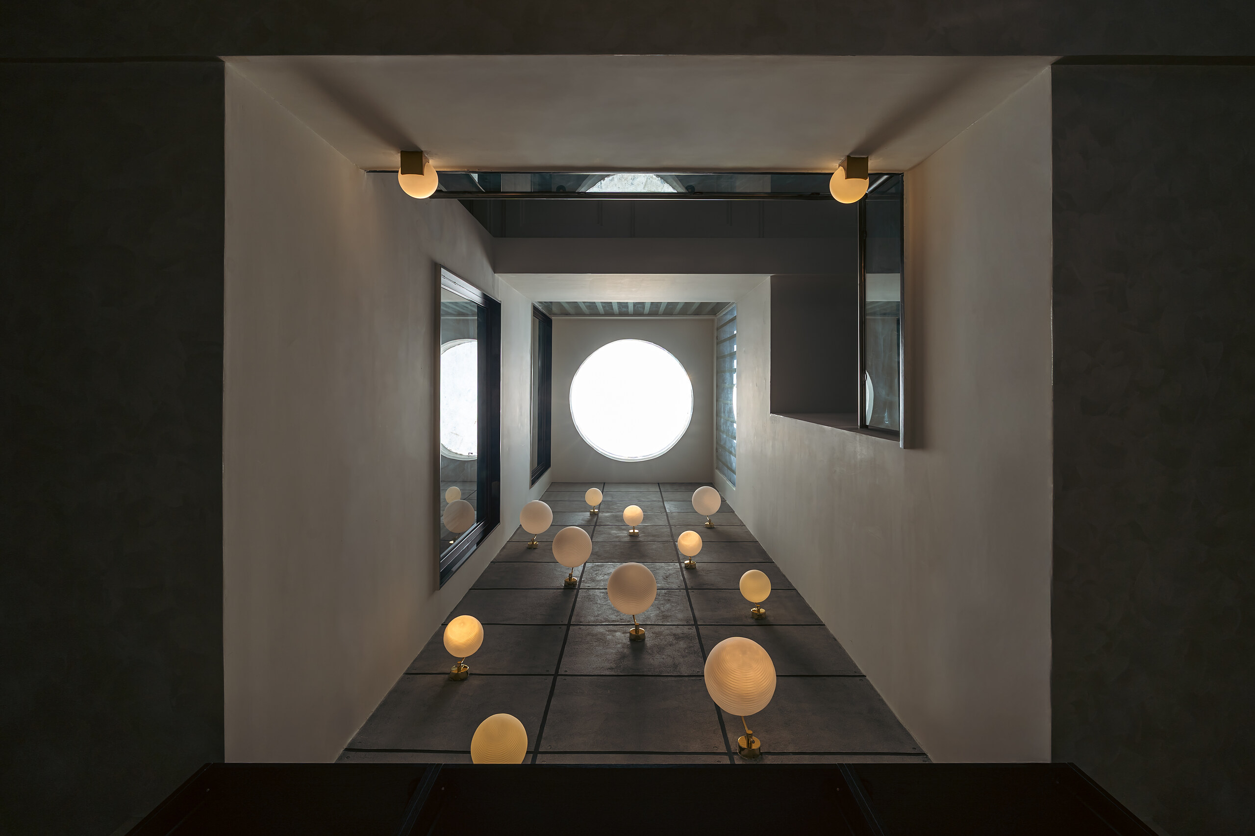 Glass spheres hang the full height of the stair void.
