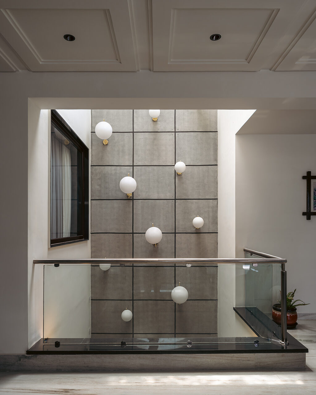 Glass spheres hang against a gridded window.