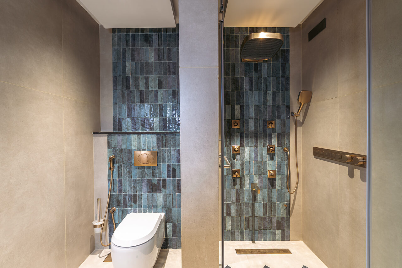 Teal tile and brass around the tub.