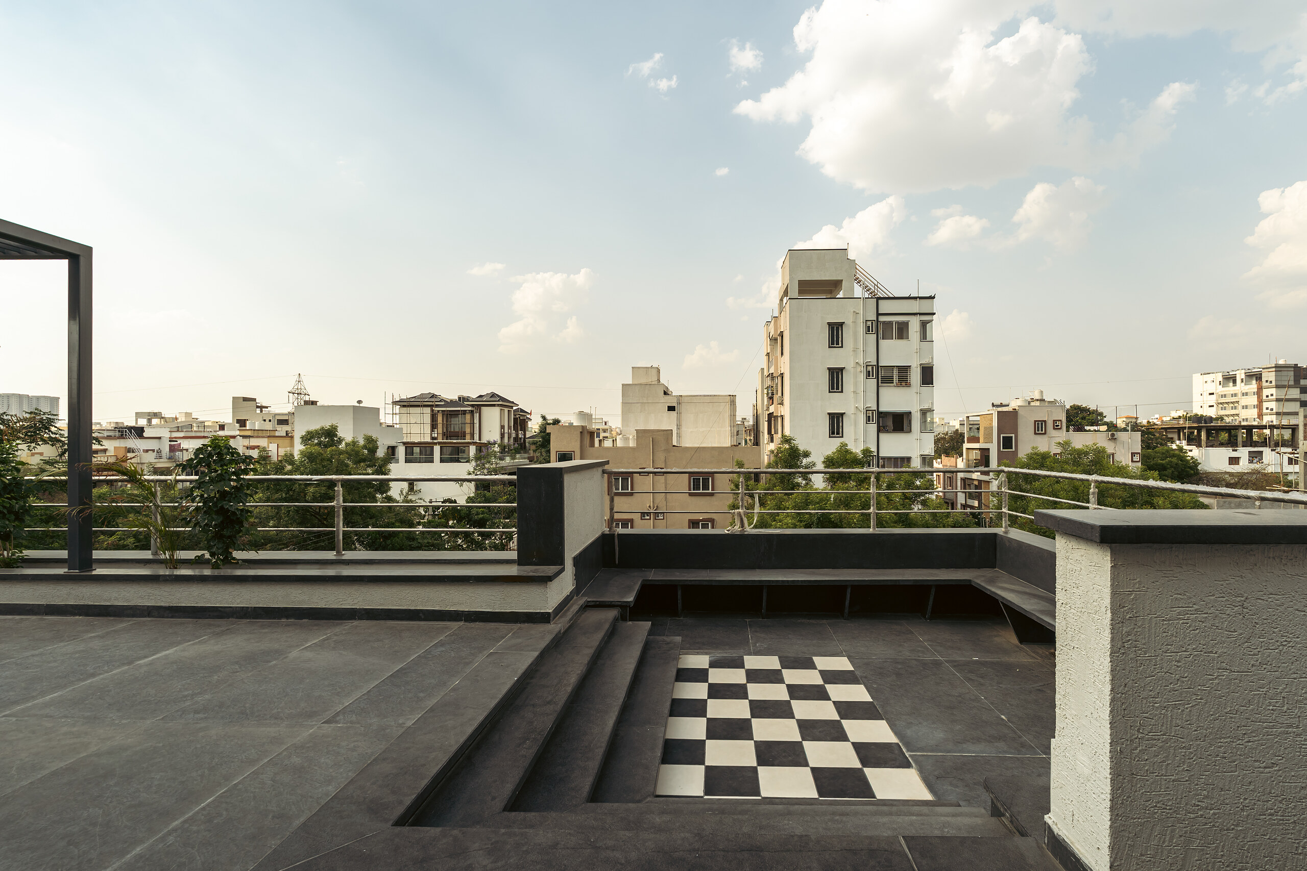 A sunken checkerboard court on the roof, skyline behind.