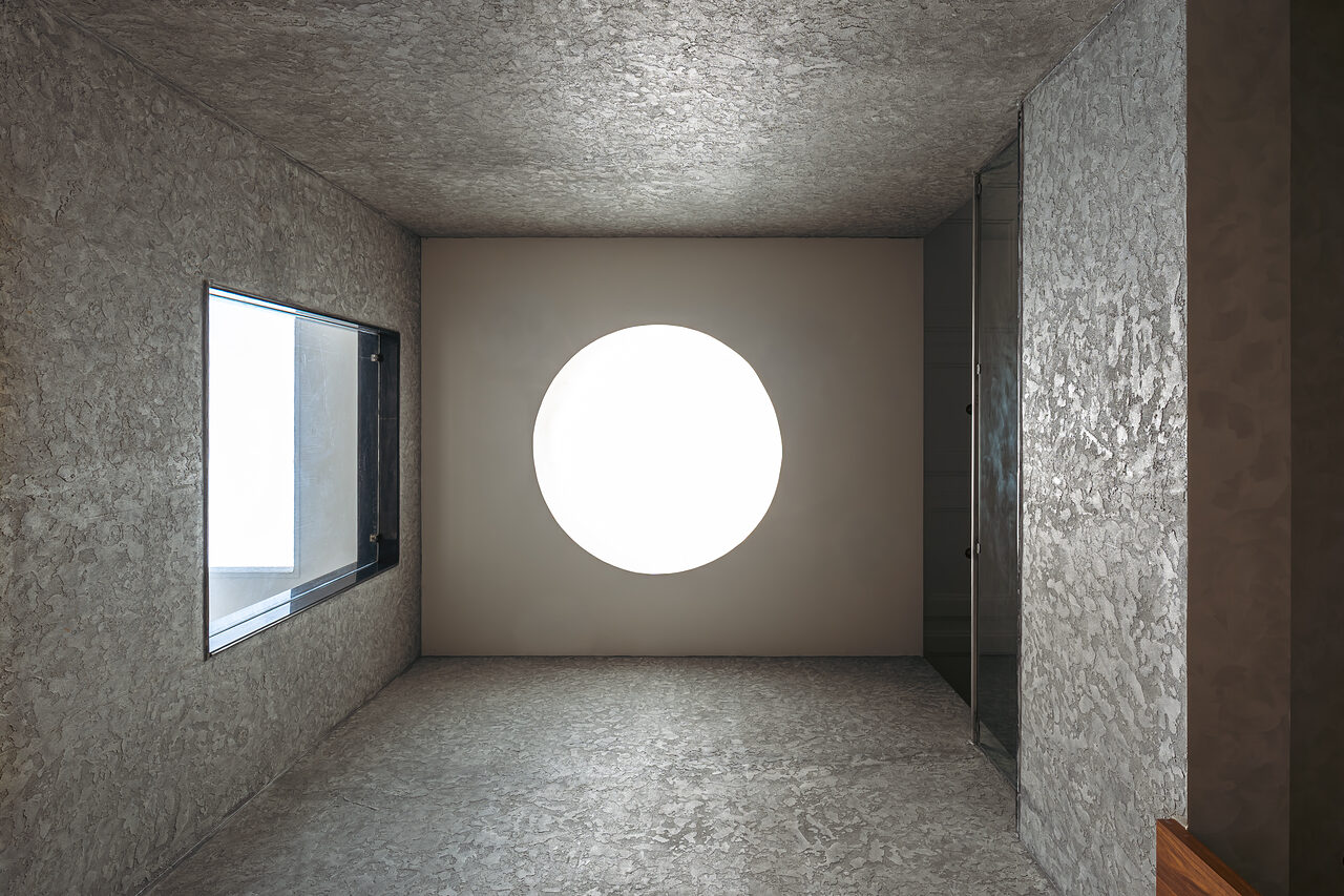 A square light shaft with a round lamp at the top.